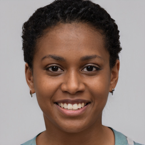 Joyful black young-adult female with short  black hair and brown eyes