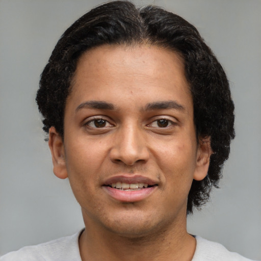 Joyful latino young-adult male with short  brown hair and brown eyes