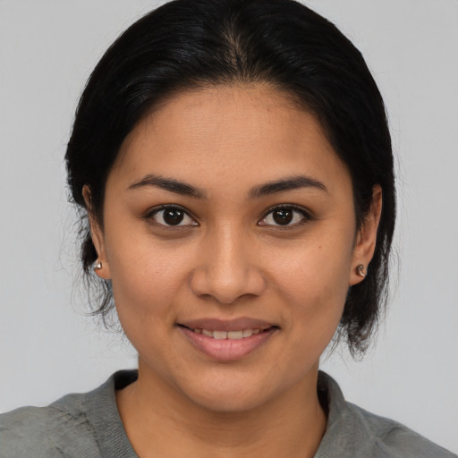 Joyful latino young-adult female with medium  black hair and brown eyes