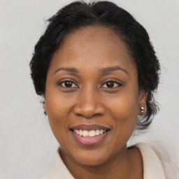 Joyful black adult female with long  brown hair and brown eyes