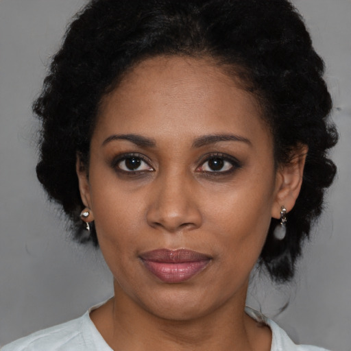 Joyful black young-adult female with short  brown hair and brown eyes