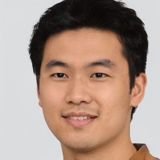 Joyful asian young-adult male with short  black hair and brown eyes