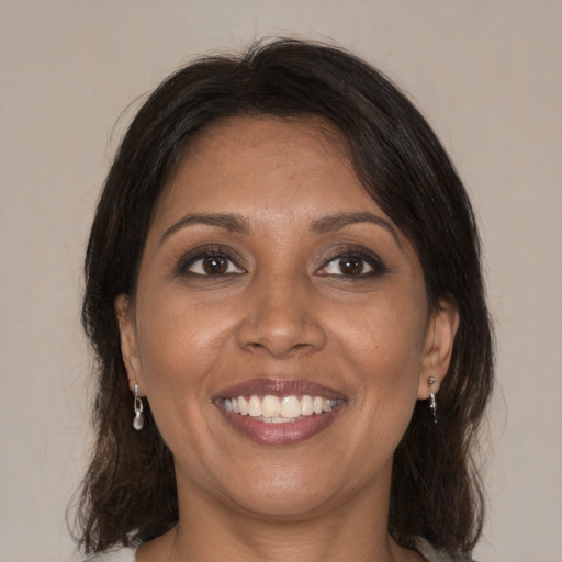 Joyful black young-adult female with medium  brown hair and brown eyes
