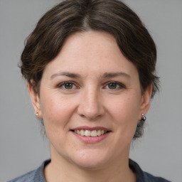 Joyful white adult female with medium  brown hair and grey eyes