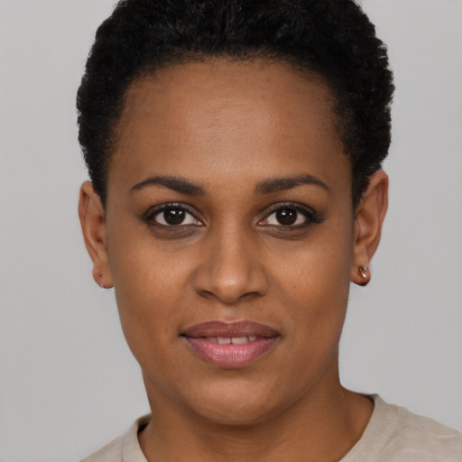 Joyful black young-adult female with short  black hair and brown eyes