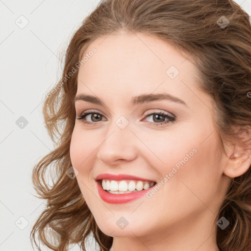 Joyful white young-adult female with long  brown hair and blue eyes