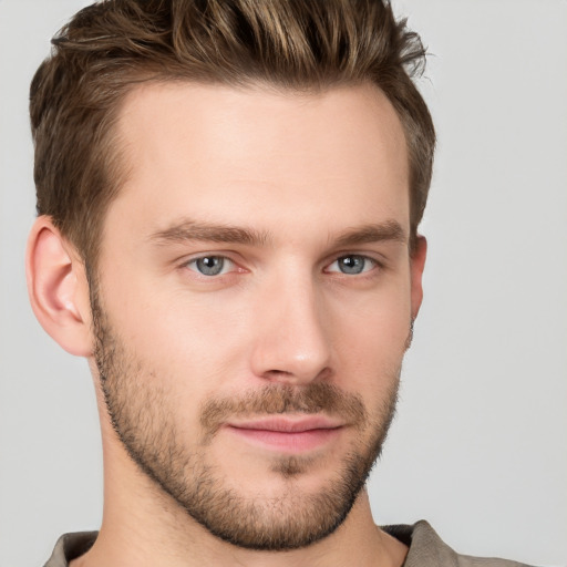 Joyful white young-adult male with short  brown hair and grey eyes