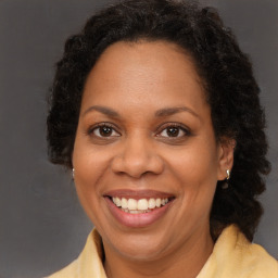 Joyful black adult female with long  brown hair and brown eyes