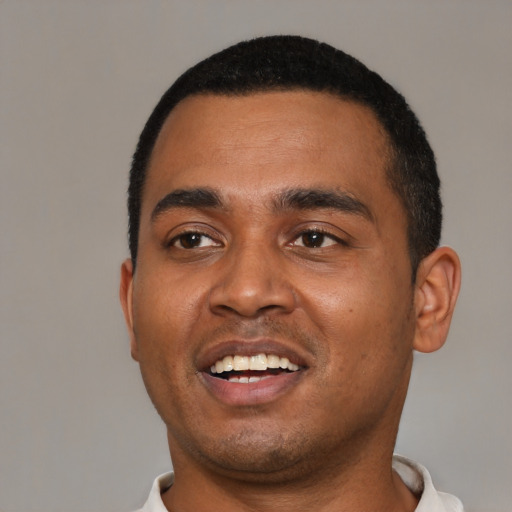 Joyful black young-adult male with short  black hair and brown eyes