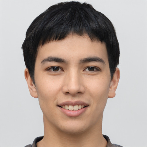 Joyful asian young-adult male with short  brown hair and brown eyes