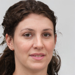 Joyful white young-adult female with medium  brown hair and green eyes