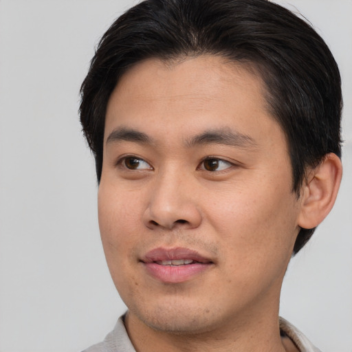 Joyful asian young-adult male with short  brown hair and brown eyes