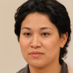 Joyful latino adult female with medium  brown hair and brown eyes