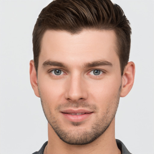 Joyful white young-adult male with short  brown hair and grey eyes