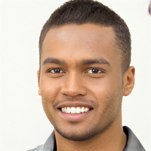 Joyful black young-adult male with short  brown hair and brown eyes