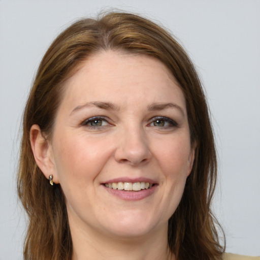 Joyful white adult female with long  brown hair and grey eyes