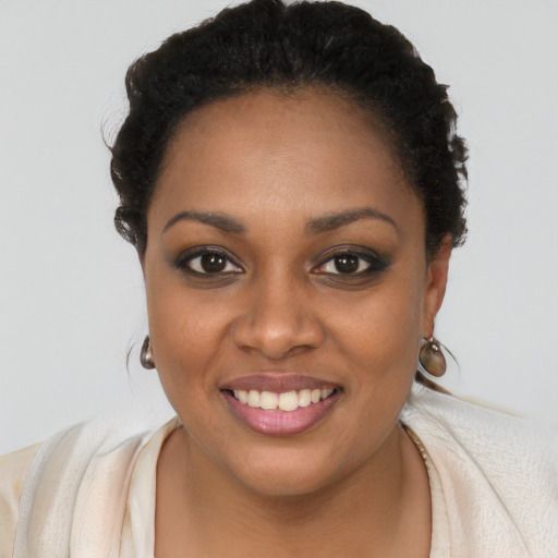 Joyful black young-adult female with long  black hair and brown eyes