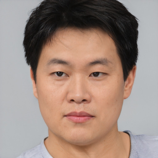 Joyful asian young-adult male with short  brown hair and brown eyes