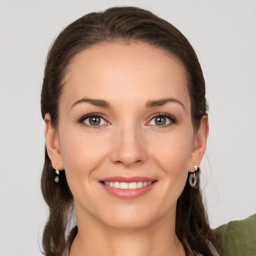 Joyful white young-adult female with long  brown hair and grey eyes