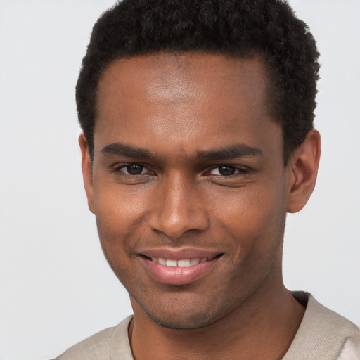 Joyful black young-adult male with short  brown hair and brown eyes