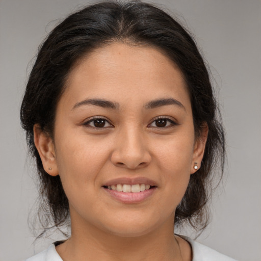 Joyful latino young-adult female with medium  brown hair and brown eyes