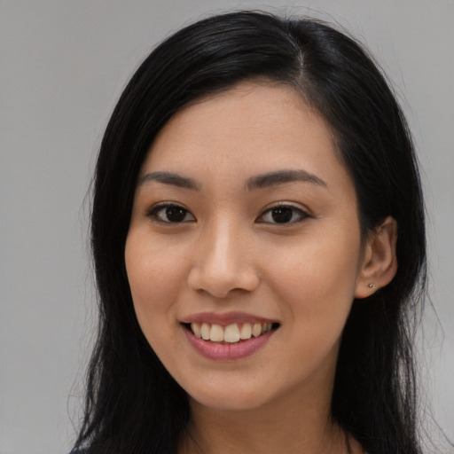 Joyful asian young-adult female with long  black hair and brown eyes