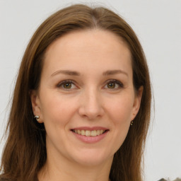 Joyful white young-adult female with long  brown hair and green eyes