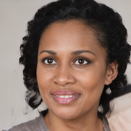 Joyful black young-adult female with medium  black hair and brown eyes