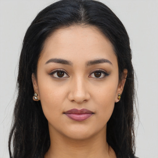 Joyful latino young-adult female with long  brown hair and brown eyes