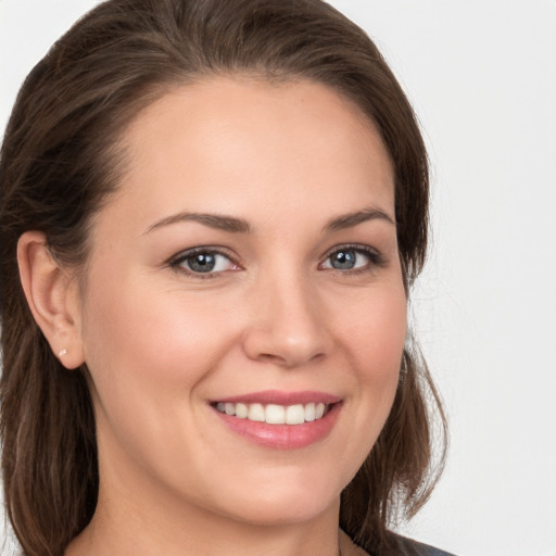 Joyful white young-adult female with medium  brown hair and grey eyes