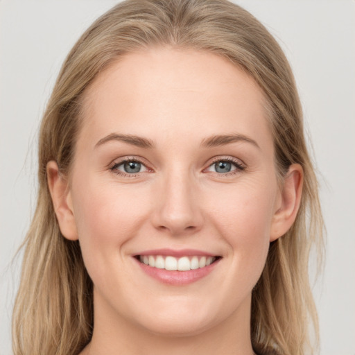 Joyful white young-adult female with long  brown hair and blue eyes