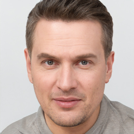 Joyful white adult male with short  brown hair and grey eyes