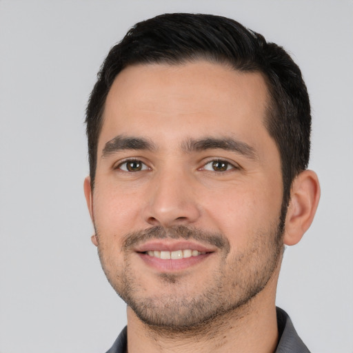 Joyful white young-adult male with short  black hair and brown eyes