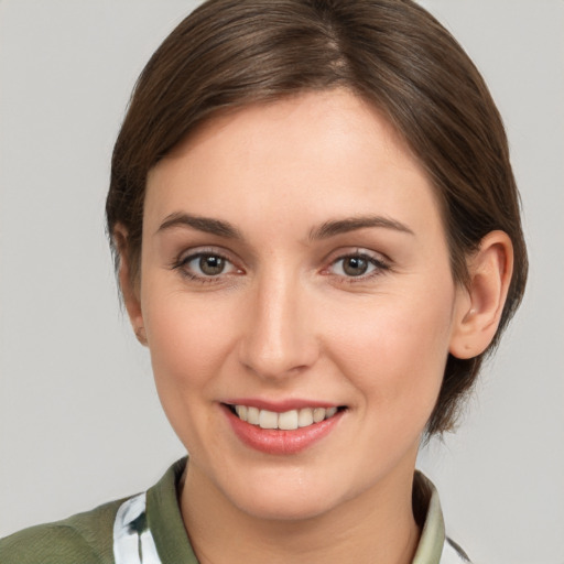 Joyful white young-adult female with medium  brown hair and grey eyes