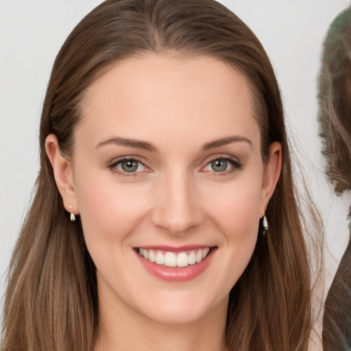 Joyful white young-adult female with long  brown hair and blue eyes