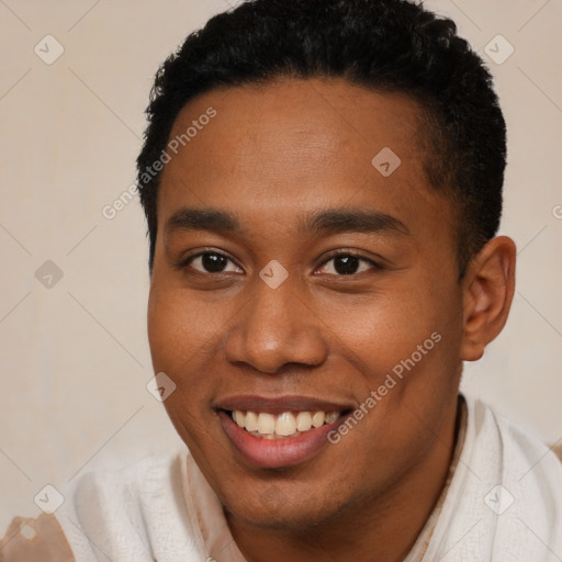 Joyful black young-adult male with short  brown hair and brown eyes