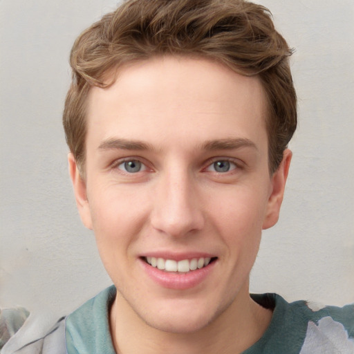 Joyful white young-adult male with short  brown hair and blue eyes