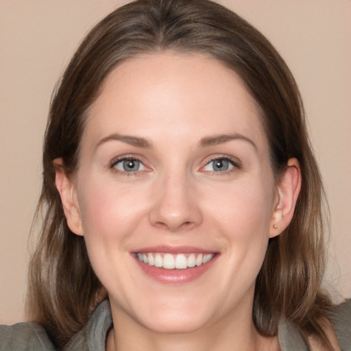 Joyful white young-adult female with long  brown hair and blue eyes