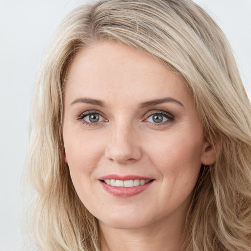 Joyful white young-adult female with long  brown hair and blue eyes