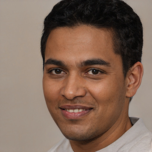 Joyful latino young-adult male with short  brown hair and brown eyes