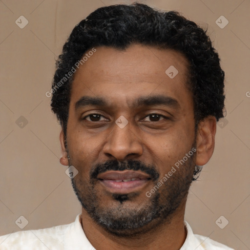 Joyful latino adult male with short  black hair and brown eyes