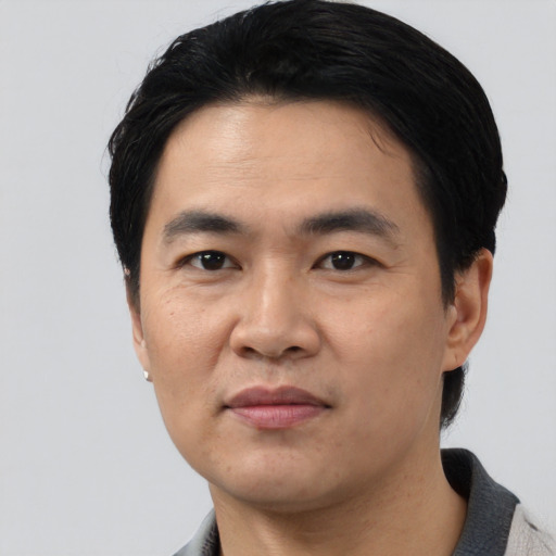 Joyful asian young-adult male with short  black hair and brown eyes