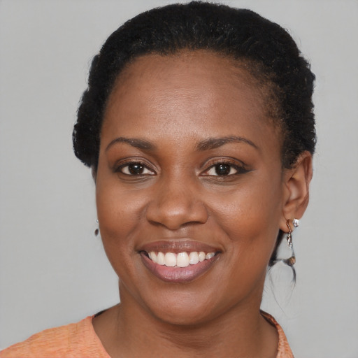 Joyful black young-adult female with short  brown hair and brown eyes