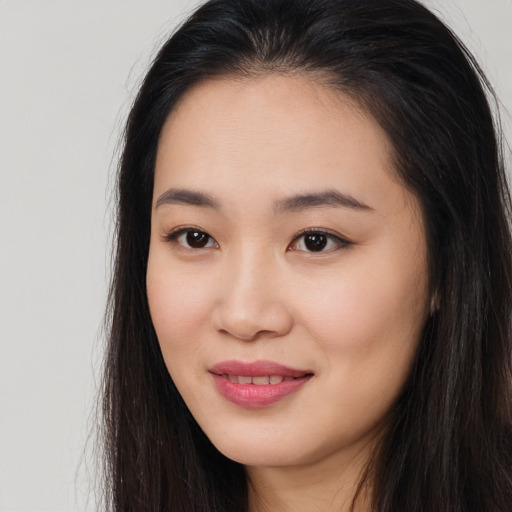 Joyful asian young-adult female with long  brown hair and brown eyes