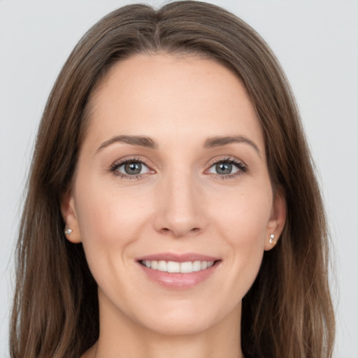 Joyful white young-adult female with long  brown hair and grey eyes