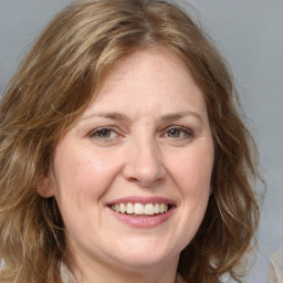 Joyful white adult female with medium  brown hair and green eyes