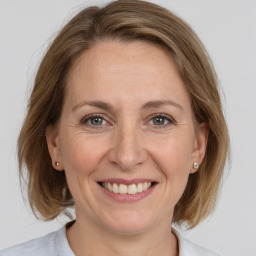 Joyful white adult female with medium  brown hair and grey eyes