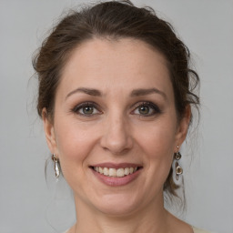 Joyful white adult female with medium  brown hair and grey eyes