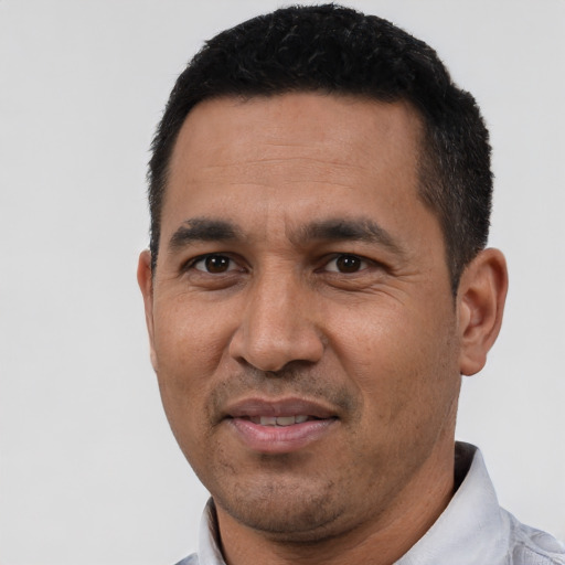 Joyful latino adult male with short  black hair and brown eyes
