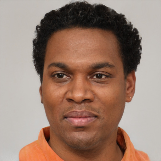 Joyful black young-adult male with short  black hair and brown eyes